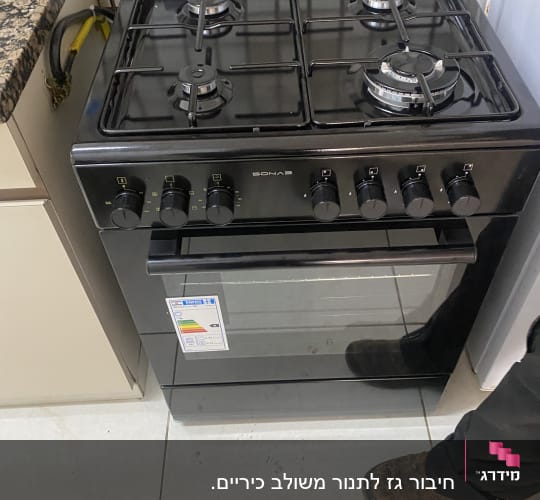 תנור גז שחור עם ארבעה מבערים וכפתורי שליטה
